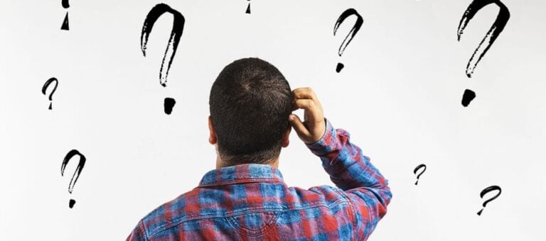 Man looking at a wall with question marks