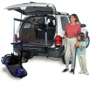 Image of a lady and a small girl using a remote control to lower her mobility scooter from the rear of her SUV using a Harmar AL065 wheelchair lift