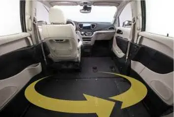 Interior image of a wheelchair van with a yellow circular arrow showing how a wheelchair has enough room for turning around inside