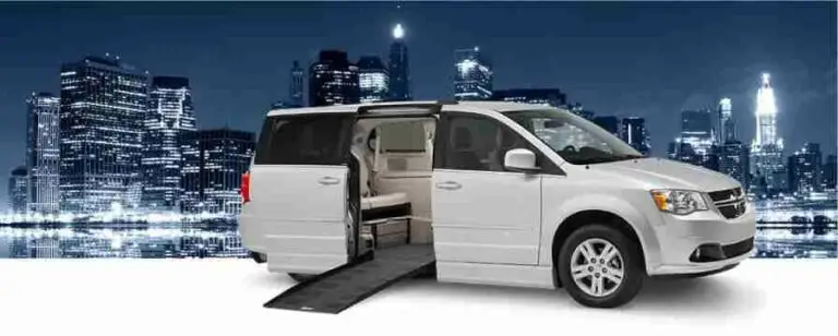 Image of a silver Dodge Caravan wheelchair van with its ramp out and a city skyline image in the background