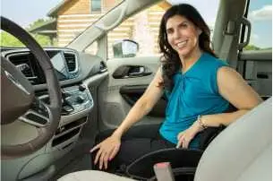 Lady in a wheelchair sitting in the passenger area of a wheelchair van