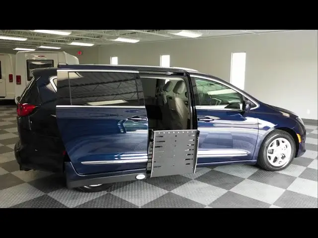 Blue chrysler pacifica wheelchair van from Adaptive Vans in a building with the ramp coming out