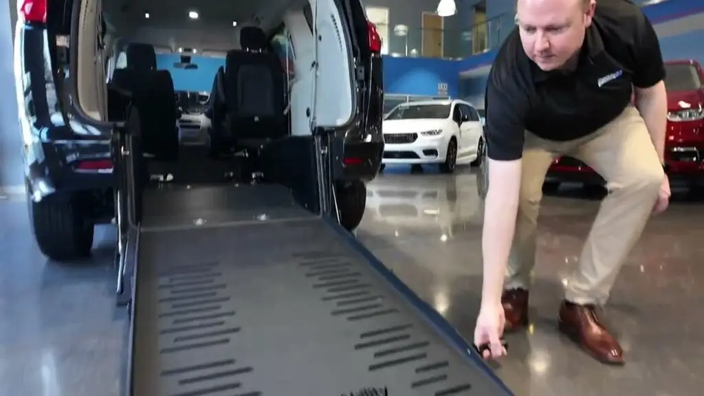 Man grabbing ramp to raise it up on a chrysler rear entry wheelchair van from braunability