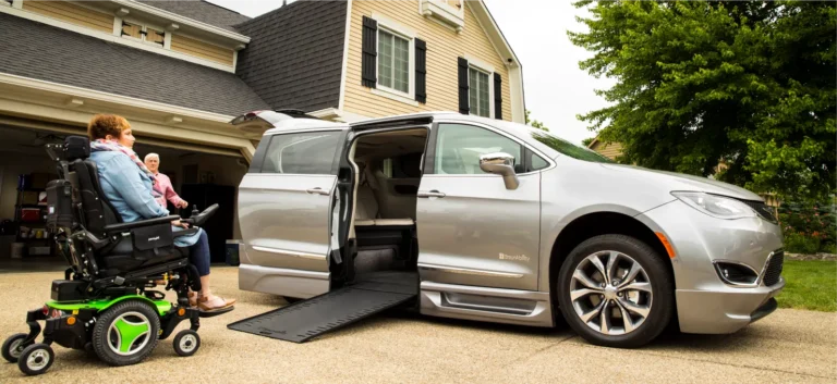 Lady in wheelchair in her driveway about to enter her new, silver, Chrysler wheelchair van from BraunAbility that was delivered to her driveway.