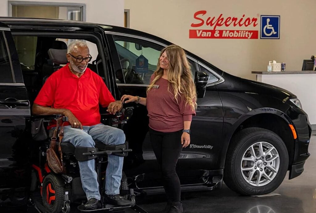 Man in a wheelchair being helped into an accessible van at Superior Van & Mobility