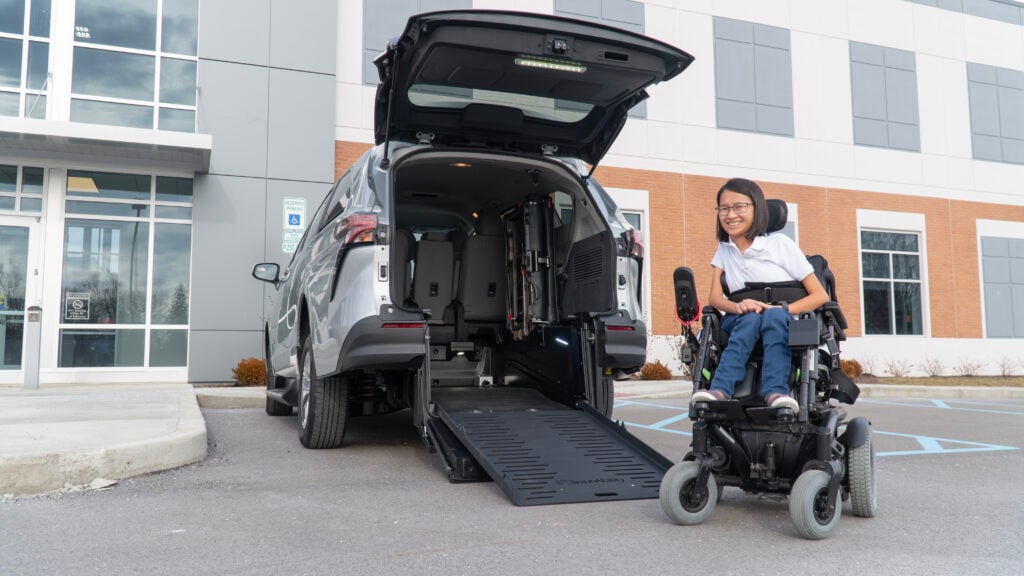 woman in wheelchair next to rear-entry van