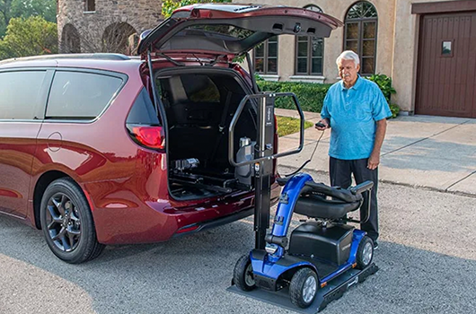 man next to scooter and exterior lift for minivan