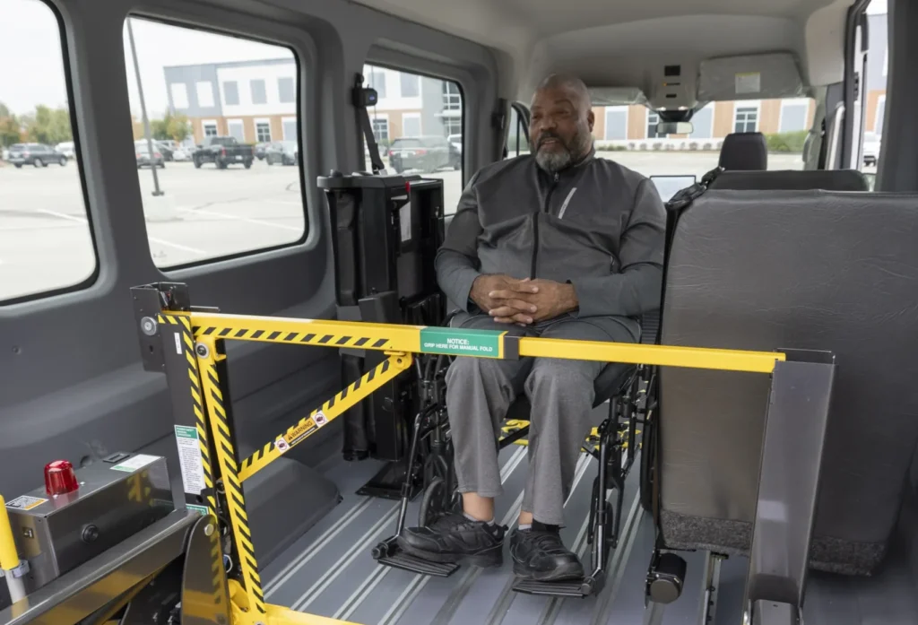 man riding in a lift in a full size van