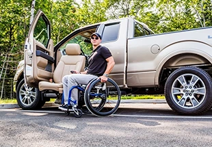 Man in adapt link seat outside of his truck