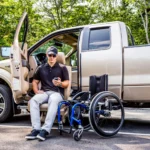 Man in adapt link seat outside of his truck